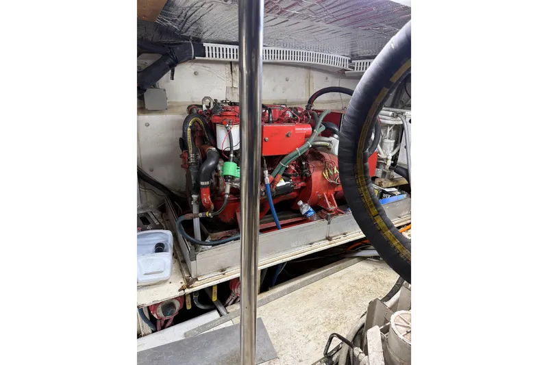 Slide: The Image of Engine room of 1988 Cheoy Lee 58 Convertible yacht, featuring red machinery and wiring. - 53