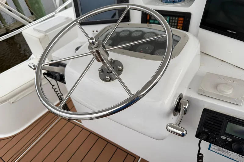 Slide: The Image of Steering wheel and controls of a 1988 Cheoy Lee 58 Convertible yacht. - 56
