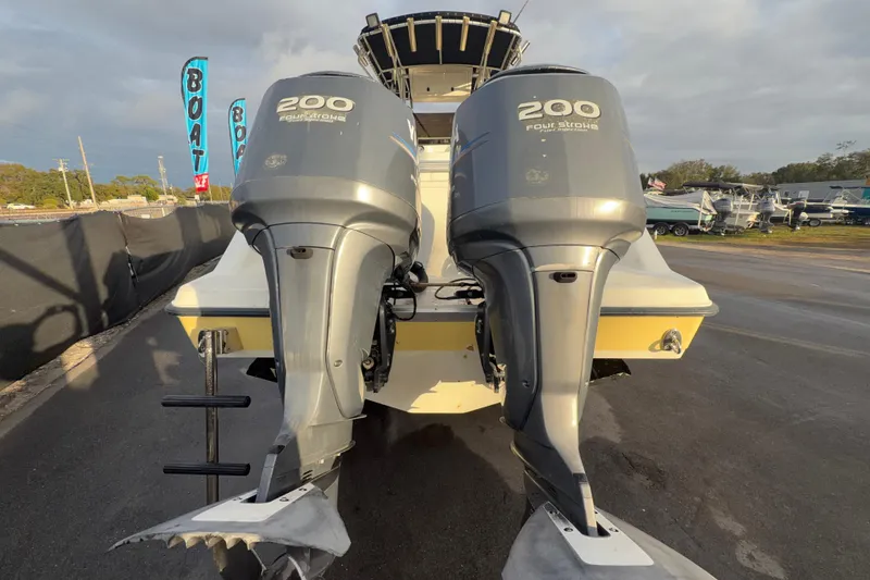Slide: The Image of 2003 Hydra-Sports Vector 2600 CC boat with dual outboard motors and propellers, parked on pavement. - 4