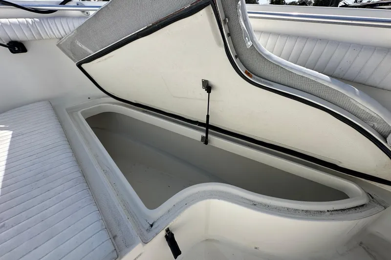 Slide: The Image of 2003 Hydra-Sports Vector 2600 CC boat storage compartment with open lid and white seating. - 53