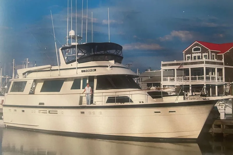 The Image of 1987 Hatteras 58 Flybridge yacht docked near waterfront buildings. - 0