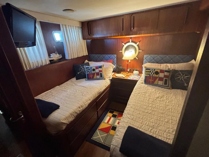 Slide: The Image of Cozy cabin interior of 1987 Hatteras Flybridge with twin beds and nautical decor. - 18