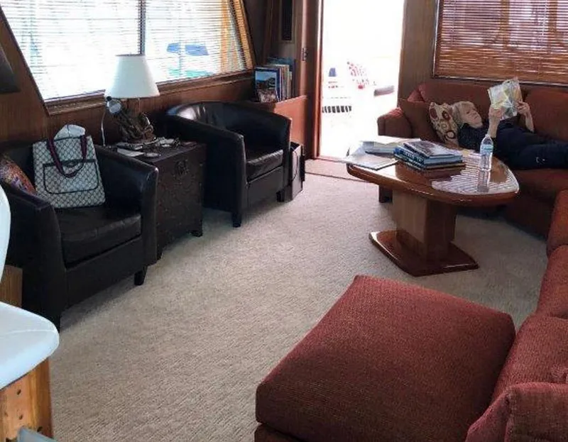 Slide: The Image of Interior of 1987 Hatteras Flybridge yacht with cozy seating and wooden table. - 2