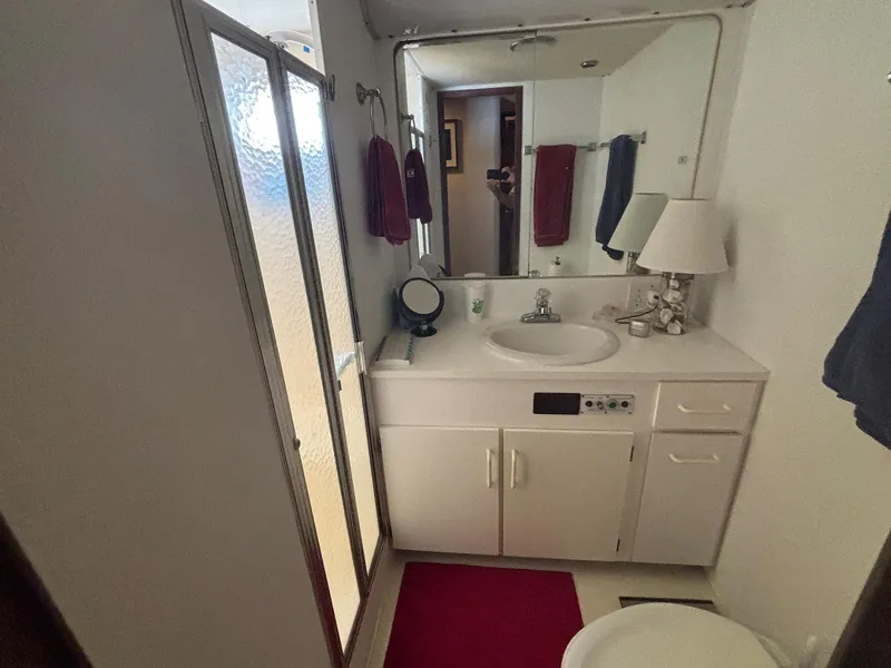 Slide: The Image of Bathroom interior of 1987 Hatteras Flybridge yacht with shower, sink, and mirror. - 21