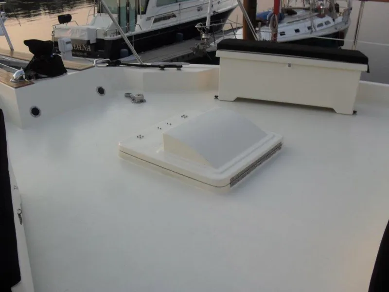 Slide: The Image of 1987 Hatteras Flybridge deck with hatch and seating, docked at marina. - 24