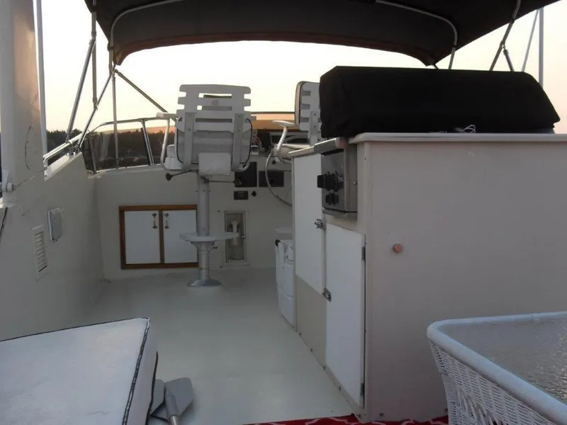 Slide: The Image of 1987 Hatteras Flybridge interior with helm, seating, and storage under a canopy. - 25