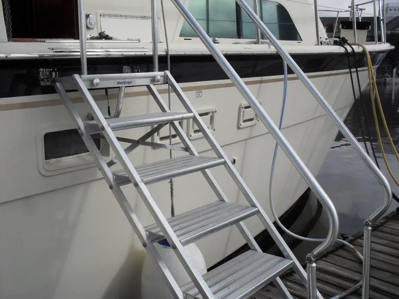 Slide: The Image of 1987 Hatteras Flybridge yacht with metal boarding stairs at dockside. - 32