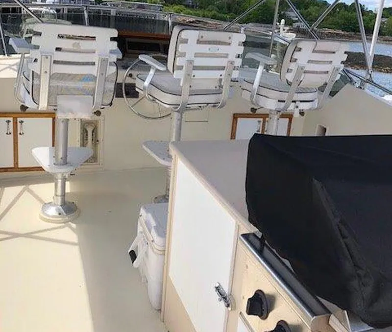 Slide: The Image of 1987 Hatteras Flybridge with white seating and outdoor kitchen area. - 41