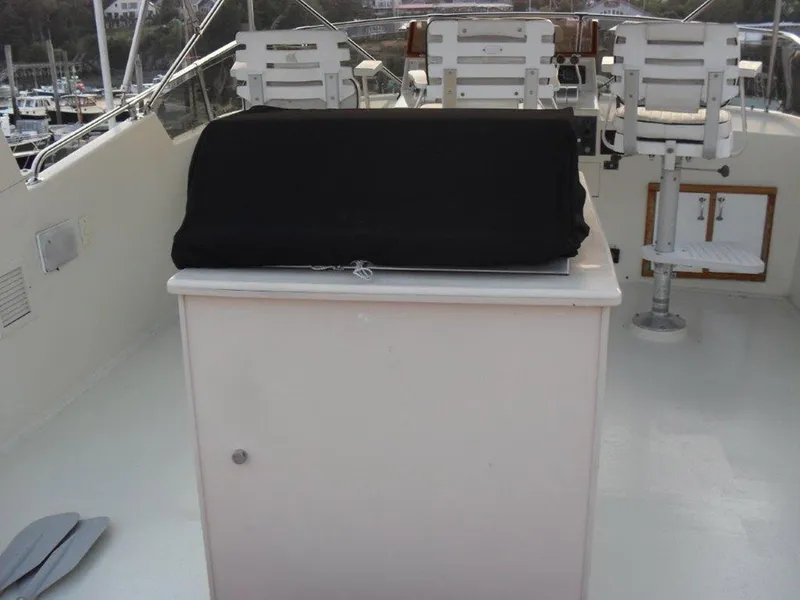 Slide: The Image of 1987 Hatteras Flybridge with covered console and seating, showcasing a classic nautical design. - 42