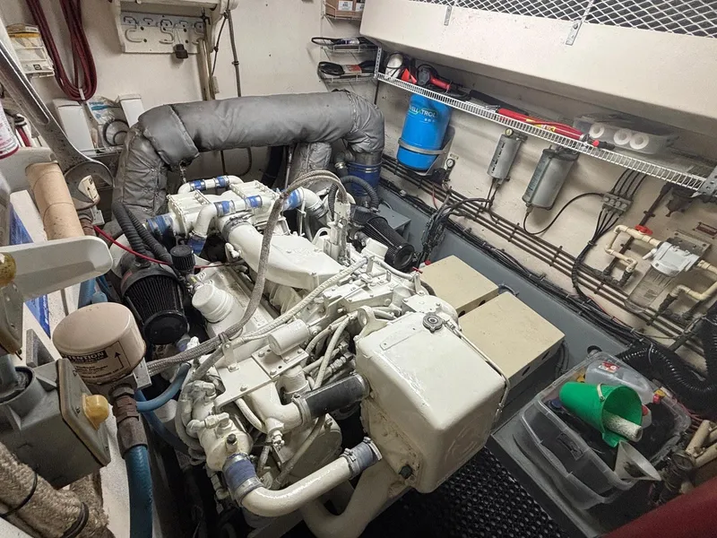 Slide: The Image of Engine room of a 1987 Hatteras Flybridge yacht, showcasing mechanical components and wiring. - 44