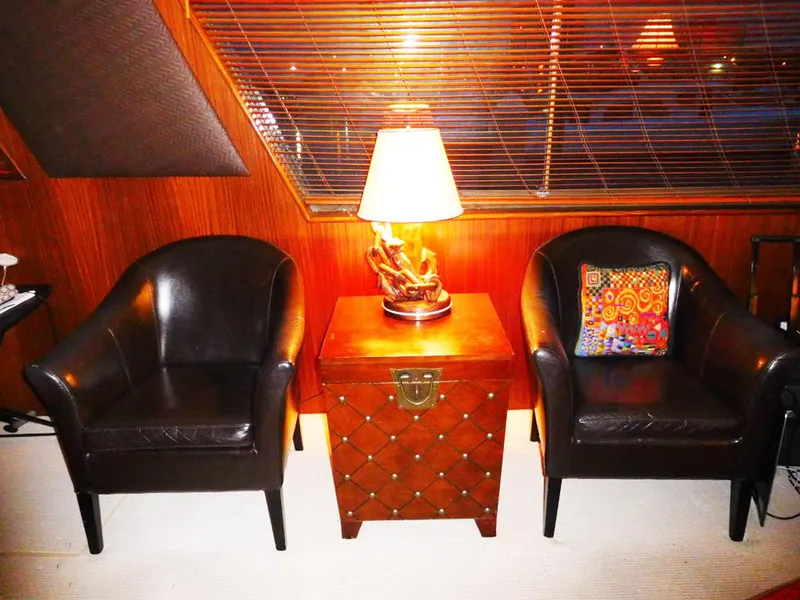 Slide: The Image of Luxurious 1987 Hatteras Flybridge interior with leather chairs, decorative lamp, and vibrant pillow. - 6