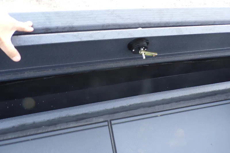 Slide: The Image of 2026 Xpress Bayou 180 storage compartment with open lid and latch detail. - 9