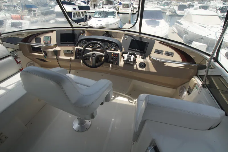 Slide: The Image of 2005 Carver 44 Cockpit Motor Yacht helm with modern controls and marina view. - 15