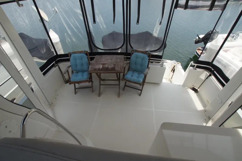 Slide: The Image of 2005 Carver 44 Cockpit Motor Yacht with seating area and table on deck. - 18