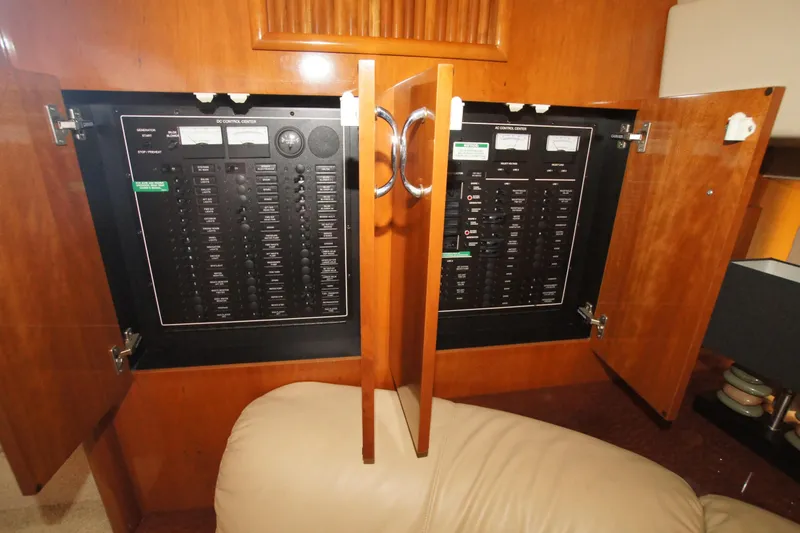 Slide: The Image of Electrical control panel inside 2005 Carver 44 Cockpit Motor Yacht, wooden cabinet open. - 9