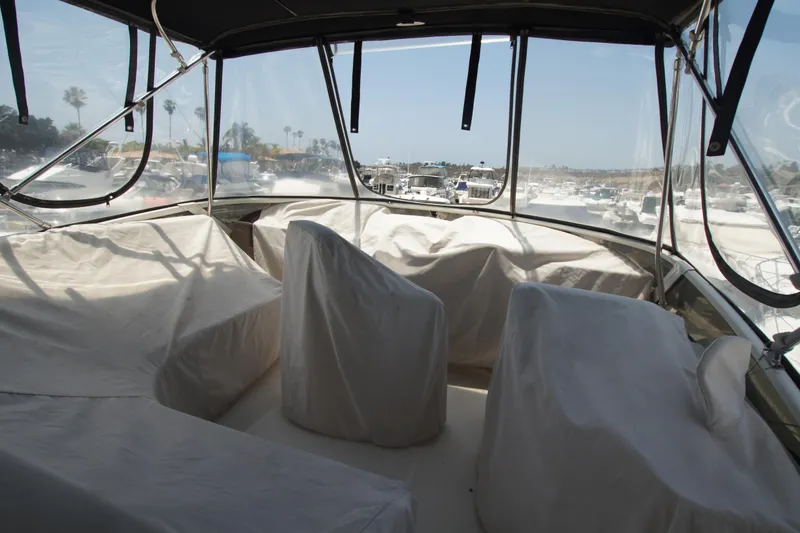 Slide: The Image of 2005 Carver 44 Cockpit Motor Yacht interior with covered seating and marina view. - 17