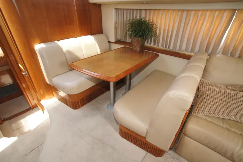 Slide: The Image of Luxurious interior of 2005 Carver 44 Cockpit Motor Yacht with plush seating and wooden table. - 5