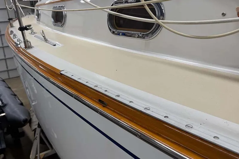 Slide: The Image of 1984 Cape Dory 25D sailboat interior with striped cushions and wooden accents. - 12