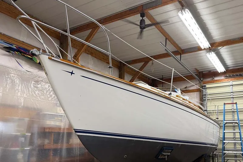 Slide: The Image of 1984 Cape Dory 25D yacht interior with wooden ladder, compact kitchen, and storage cabinets. - 14
