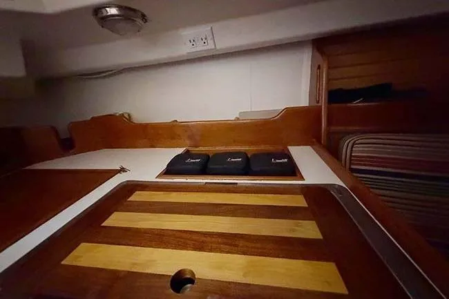 Slide: The Image of Interior of a 1984 Cape Dory 25D sailboat with wooden table and seating. - 16