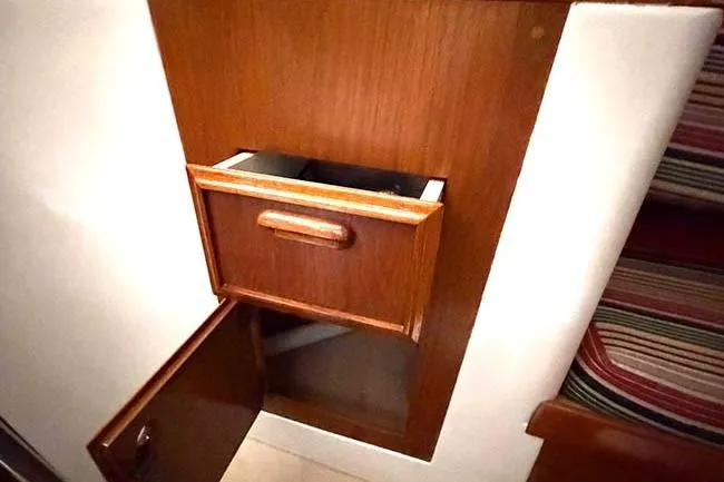 Slide: The Image of 1984 Cape Dory 25D interior with wooden drawer and cabinet, showcasing classic nautical design. - 17