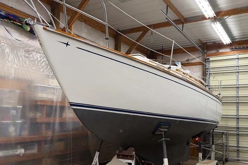 Slide: The Image of 1984 Cape Dory 25D sailboat in indoor storage, showcasing sleek design and craftsmanship. - 25