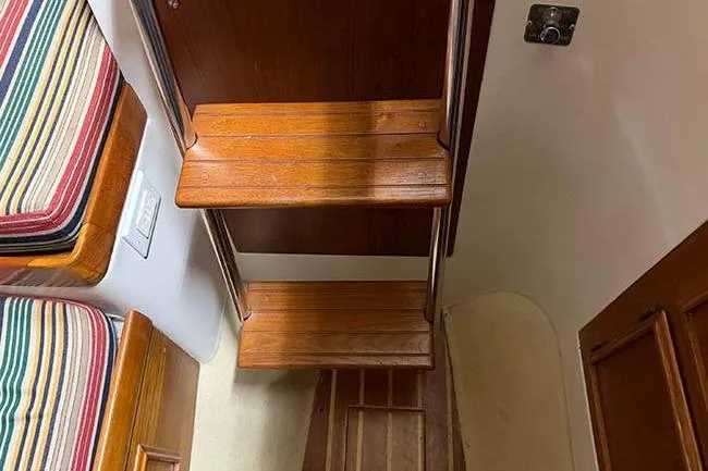 Slide: The Image of 1984 Cape Dory 25D sailboat deck with polished wood and metal fittings. - 3