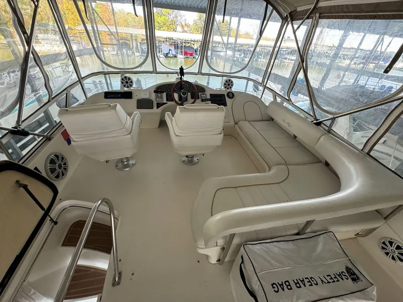 Slide: The Image of Interior of 1996 Sea Ray 400 Sedan Bridge yacht with white seating and helm. - 13
