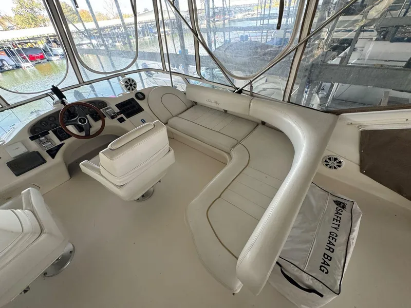 Slide: The Image of 1996 Sea Ray 400 Sedan Bridge interior with white seating and safety gear bag. - 14