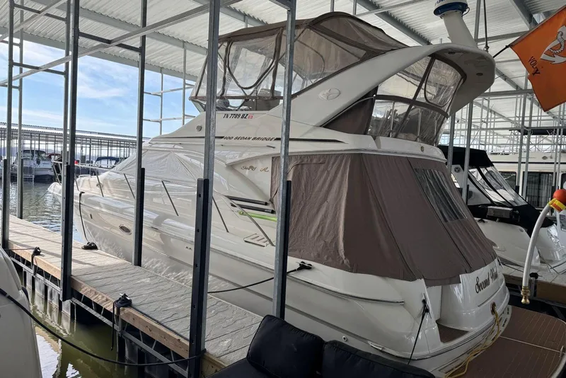 Slide: The Image of 1996 Sea Ray 400 Sedan Bridge yacht docked in a marina under a covered structure. - 2