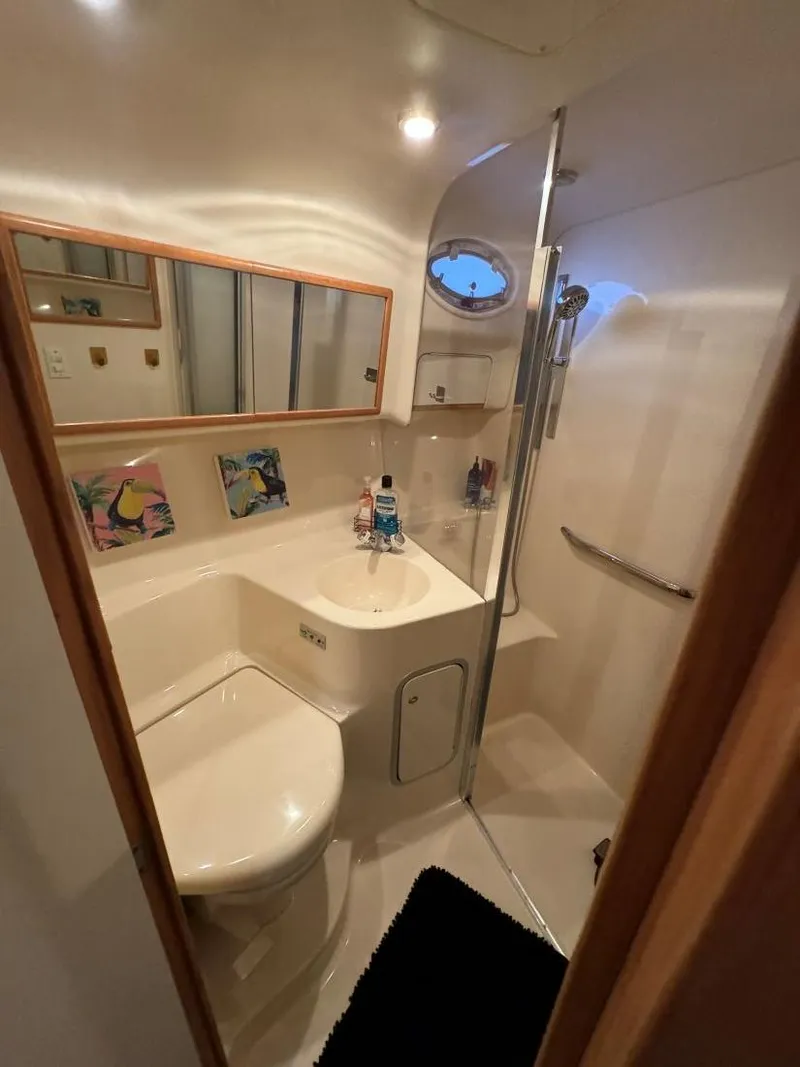 Slide: The Image of Bathroom interior of 1996 Sea Ray 400 Sedan Bridge yacht, featuring shower and toilet. - 32