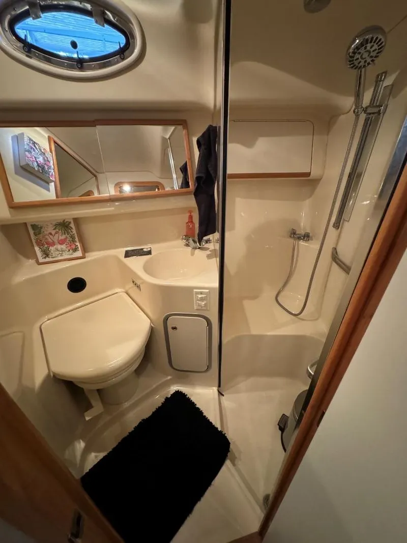 Slide: The Image of 1996 Sea Ray 400 Sedan Bridge bathroom with shower, sink, and porthole window. - 34