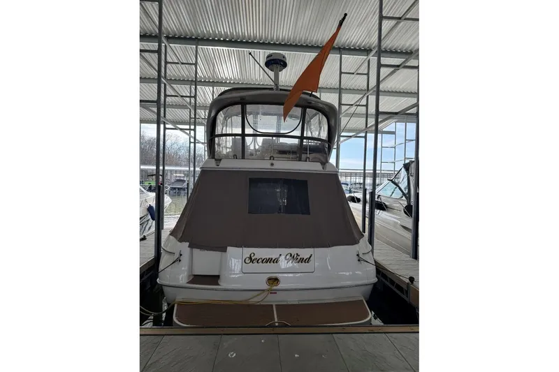 Slide: The Image of 1996 Sea Ray 400 Sedan Bridge docked, rear view with canopy and flag. - 4
