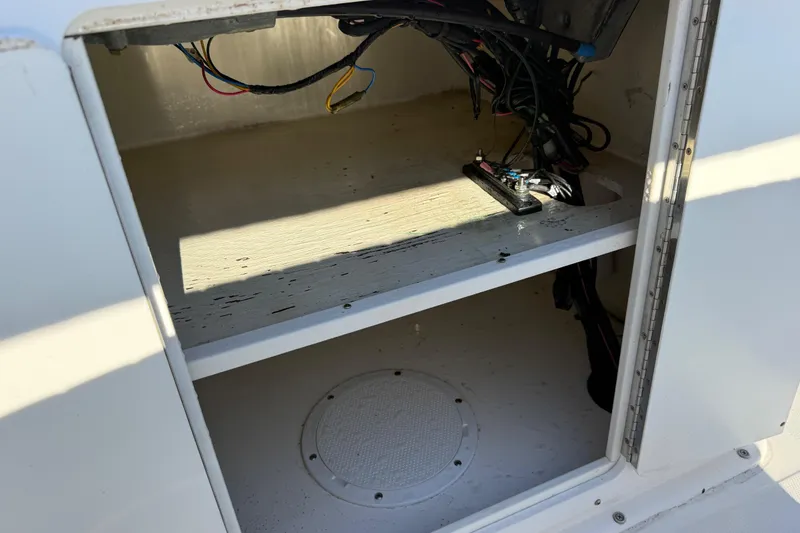 Slide: The Image of Open storage compartment in a 2010 Maycraft 1900 boat, showing wiring and interior details. - 12