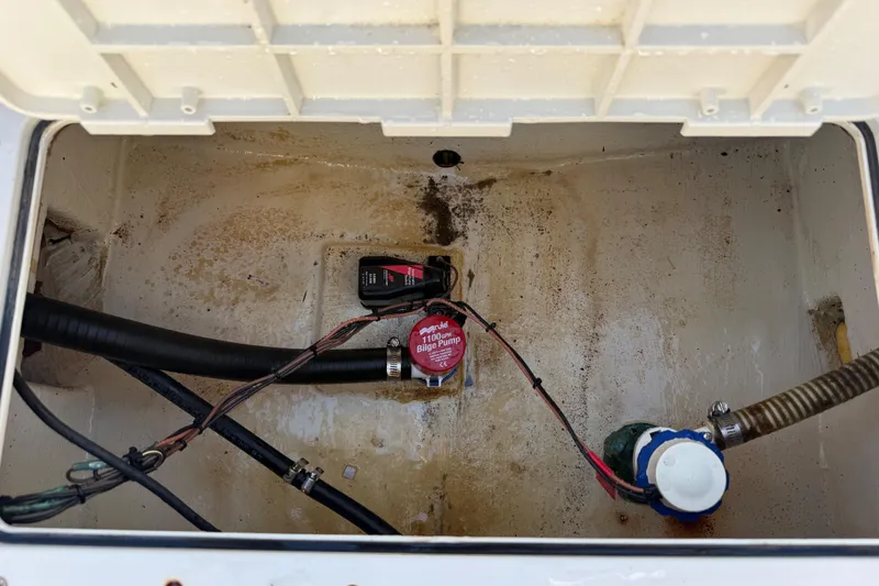 Slide: The Image of 2010 Maycraft 1900 bilge area with pump and hoses, showing interior details. - 13