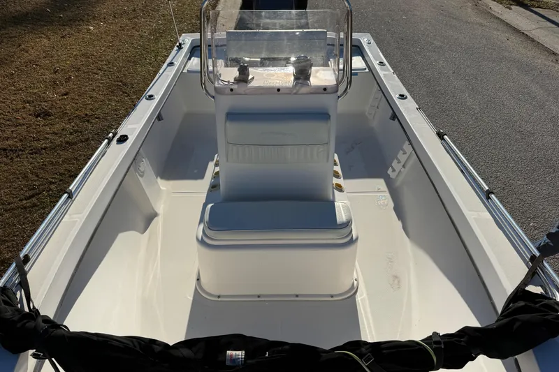 Slide: The Image of 2010 Maycraft 1900 boat interior with center console and seating, parked on a sunny day. - 6