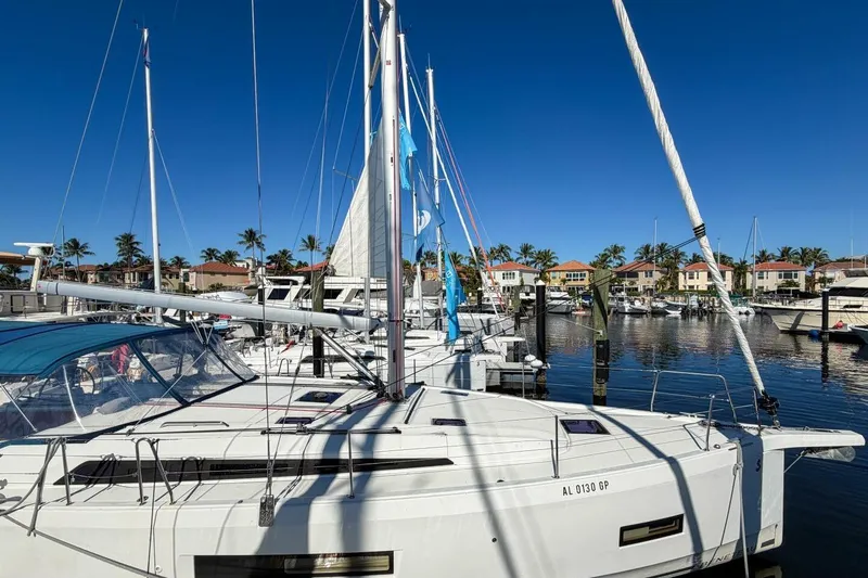 Slide: The Image of 2022 Beneteau Oceanis 40.1 sailboat docked at marina, featuring sleek design and blue canopy. - 107
