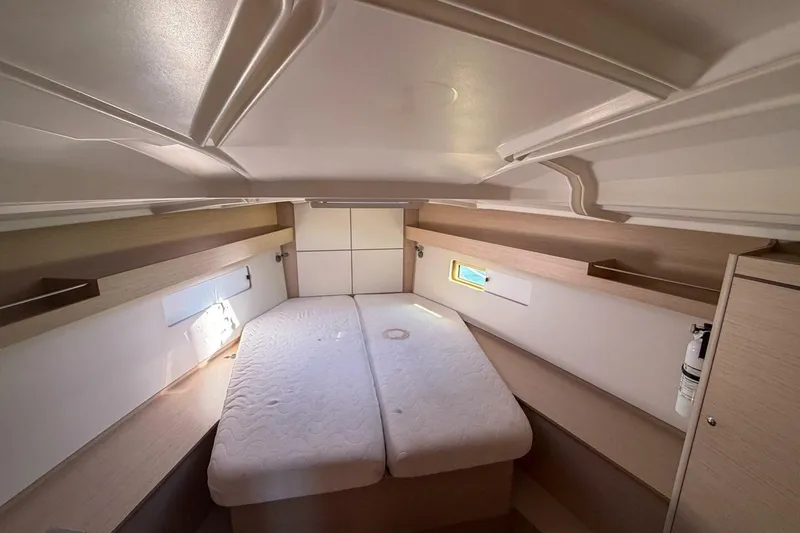Slide: The Image of 2022 Beneteau Oceanis 40.1 cabin interior with bed, storage, and natural light. - 11