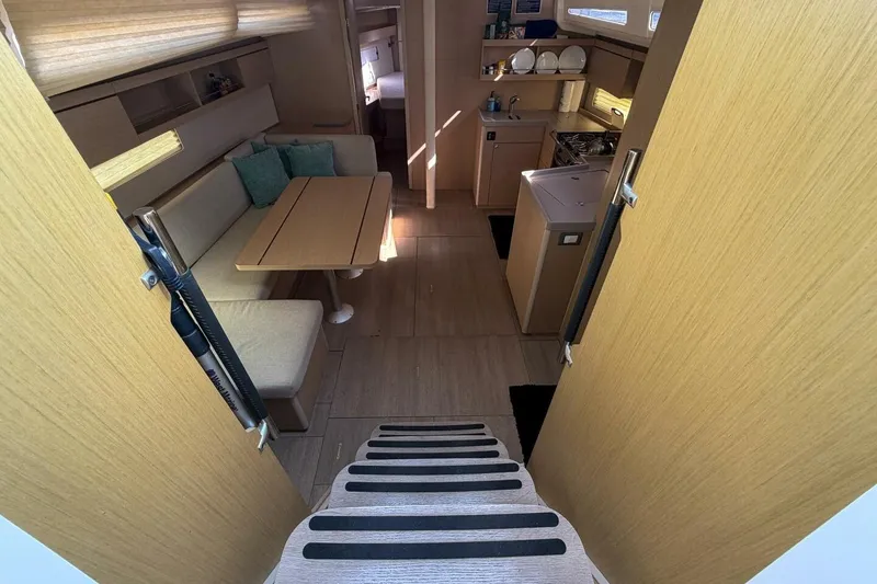 Slide: The Image of Interior of 2022 Beneteau Oceanis 40.1 yacht, featuring cozy seating and modern kitchen. - 2