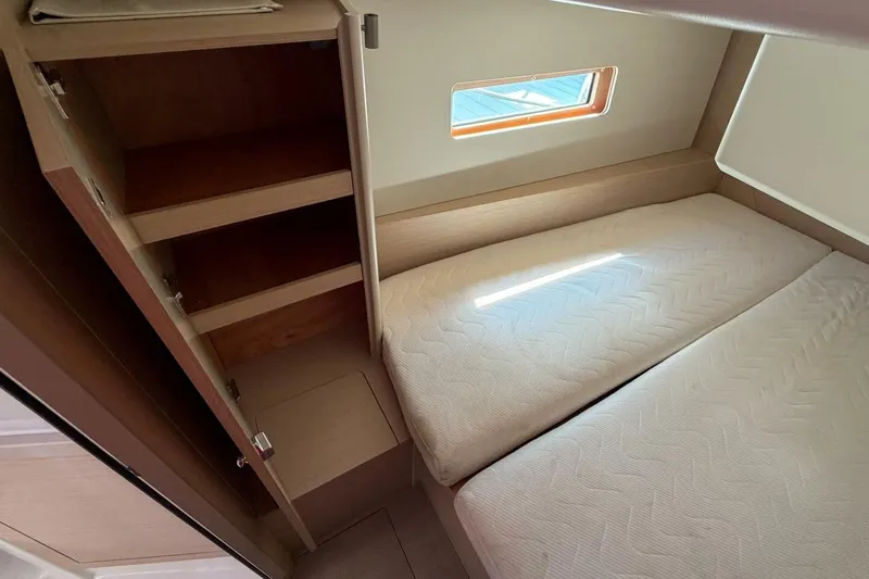 Slide: The Image of 2022 Beneteau Oceanis 40.1 cabin interior with twin beds and storage shelves. - 22