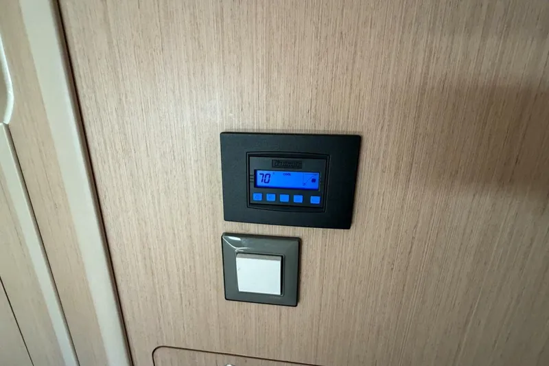 Slide: The Image of Thermostat and switch on Beneteau Oceanis 40.1 yacht, 2022 model, wooden panel background. - 23