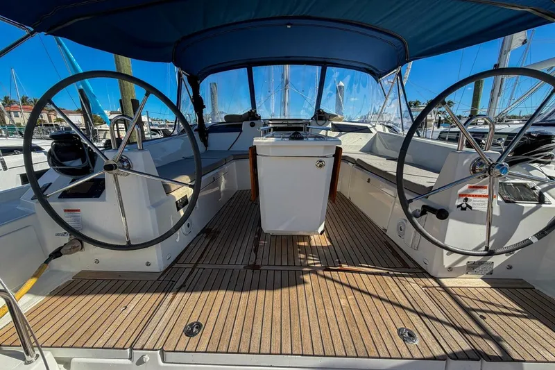 Slide: The Image of 2022 Beneteau Oceanis 40.1 yacht with dual steering wheels and teak deck in marina. - 50