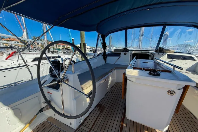 Slide: The Image of 2022 Beneteau Oceanis 40.1 yacht cockpit with dual steering wheels and teak flooring. - 58