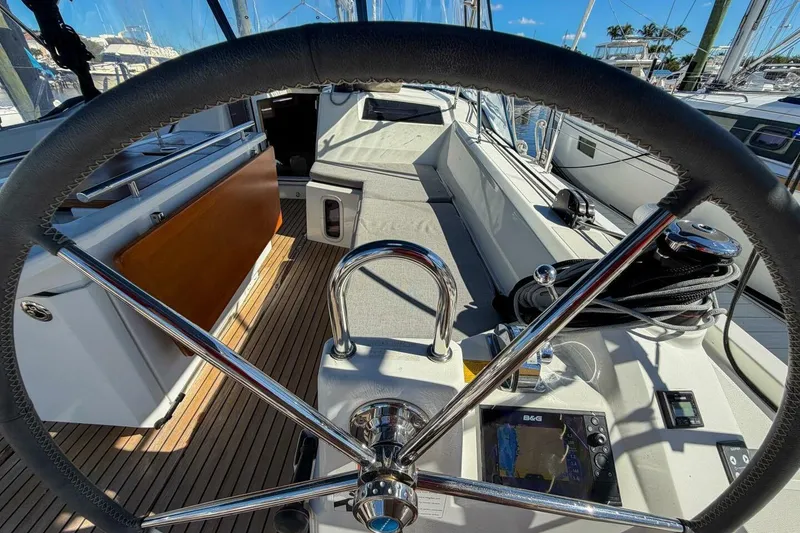 Slide: The Image of 2022 Beneteau Oceanis 40.1 sailboat cockpit with steering wheel and wooden deck. - 63
