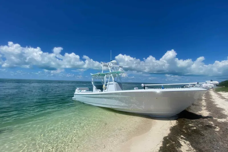 Slide: The Image of 2023 Andros Offshore 32 boat on sandy beach with clear blue sky and ocean. - 3