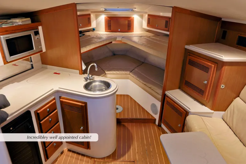 Slide: The Image of Luxurious 2000 Cabo 35 Express cabin interior with kitchenette and cozy seating. - 19