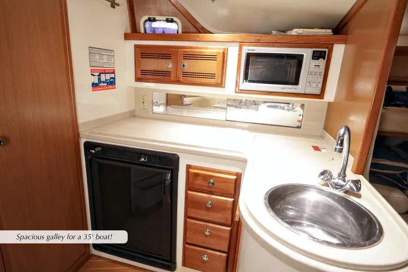 Slide: The Image of Spacious galley in 2000 Cabo 35 Express boat with sink, microwave, and storage. - 23