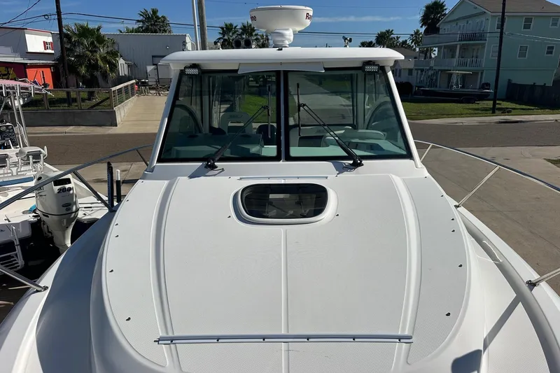 Slide: The Image of 2012 Boston Whaler 315 Conquest boat, front deck view with windshield and hatch. - 11