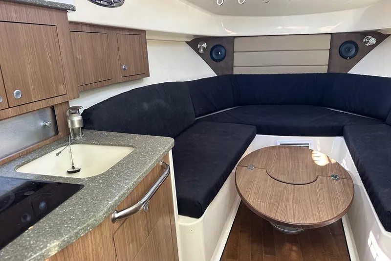 Slide: The Image of Interior of 2012 Boston Whaler 315 Conquest with seating, table, and kitchenette. - 12