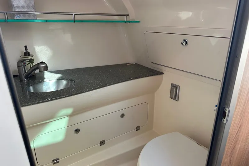 Slide: The Image of 2012 Boston Whaler 315 Conquest boat bathroom with sink, countertop, and storage. - 13